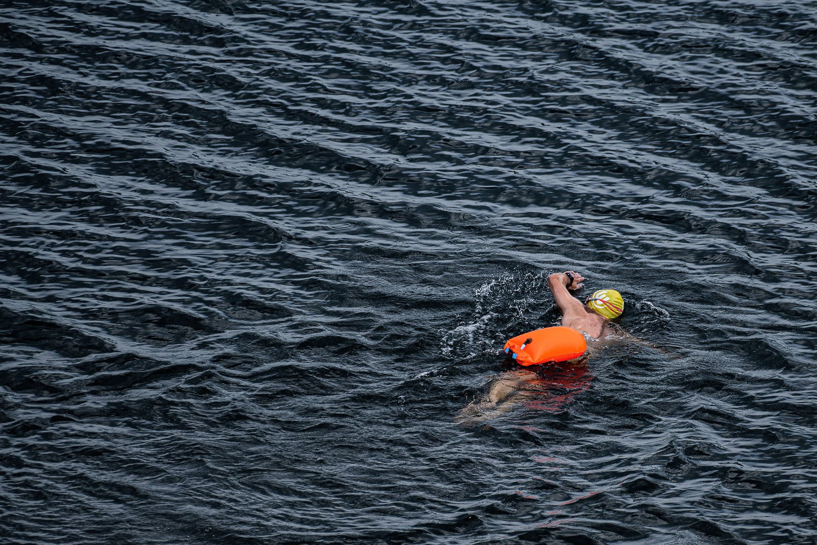 Leuchtend orange, pink oder gelb zieht sie hinter Schwimmern durchs Wasser: die Schwimmboje, befestigt über einen Gürtel. (Symbolbild)
