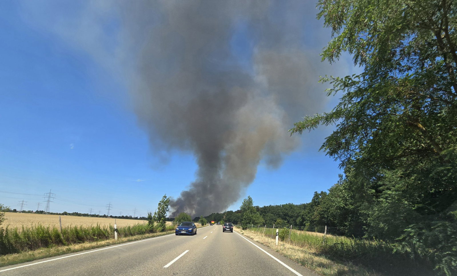 Eine Rauchsäule steigt am Fahrbahnrand der B36 in Linkenheim-Hochstetten auf.