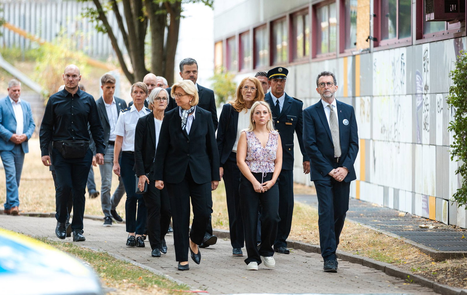 Ministerpräsidentin Anke Rehlinger (SPD), Selina Bohr, Witwe des getöteten Polizeioberkommissars Simon Bohr, und Saarlands Innenminister Reinhold Jost (SPD) führen den Trauermarsch von der Polizeiinspektion Völklingen zur Gedenkstele am damaligen Tatort …