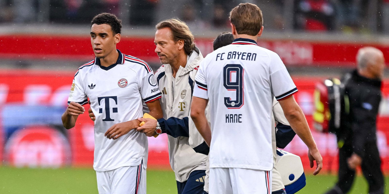Supercup ohne Jamal Musiala. Der Nationalspieler wird nach seinem zweiten Zusammenbruch - hier in Heidenheim mit Bayerns Teamarzt - in Dortmund nicht auflaufen. 
