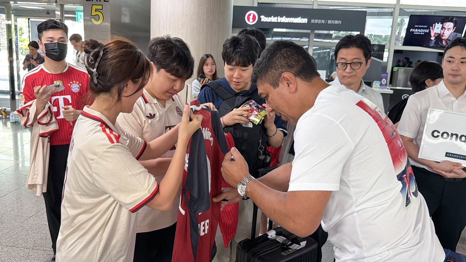 Der frühere Bayern-Profi Giovane Elber gibt Autogramme (vorne r) am Flughafen.