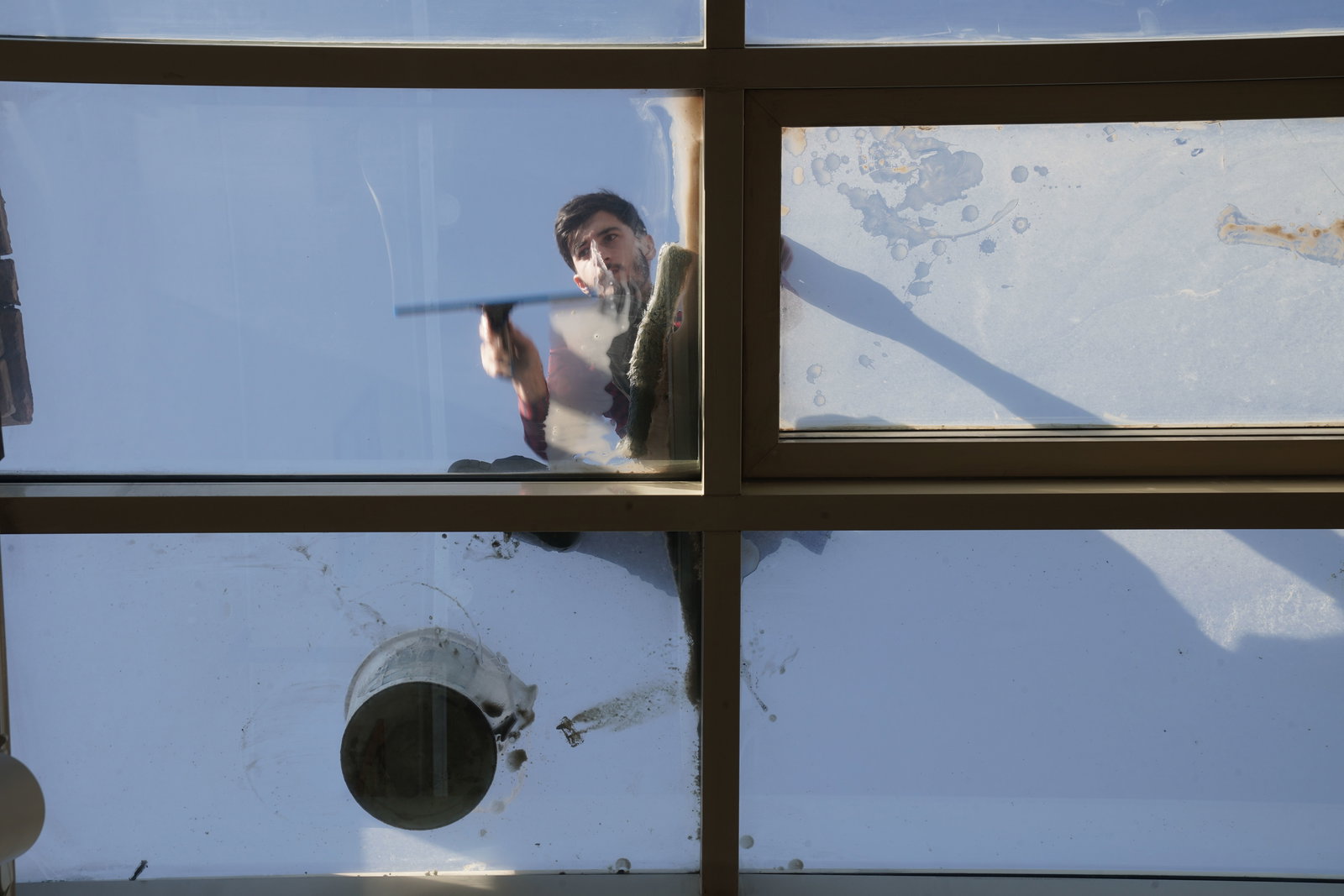 Mann putzt Fenster