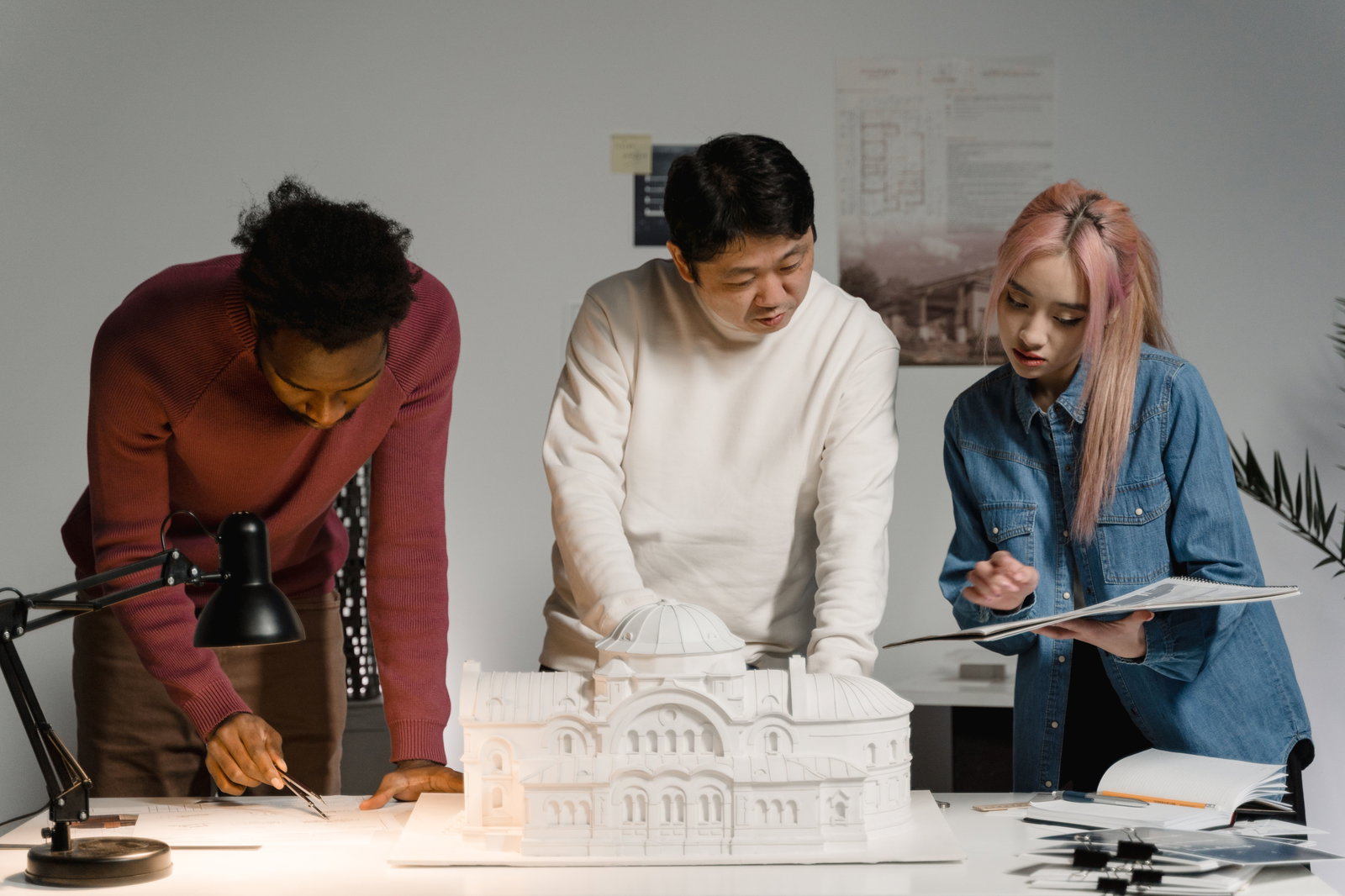 Drei Menschen begutachten Architektur Miniatur
