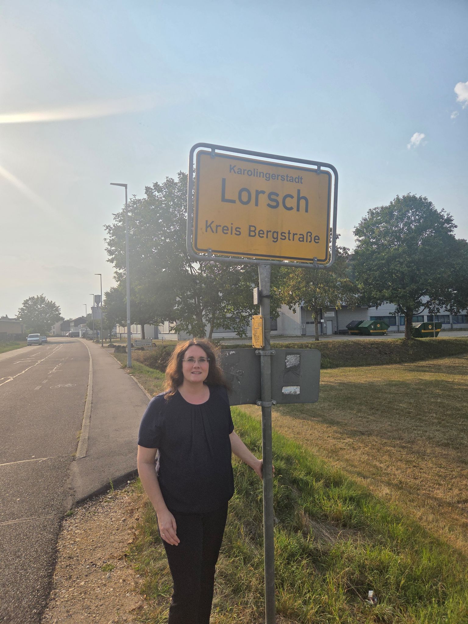 Die Bürgermeisterin von Lorch im Ostalbkreis, Marita Funk, neben dem vertauschten Schild der hesssischen Gemeinde Lorsch.