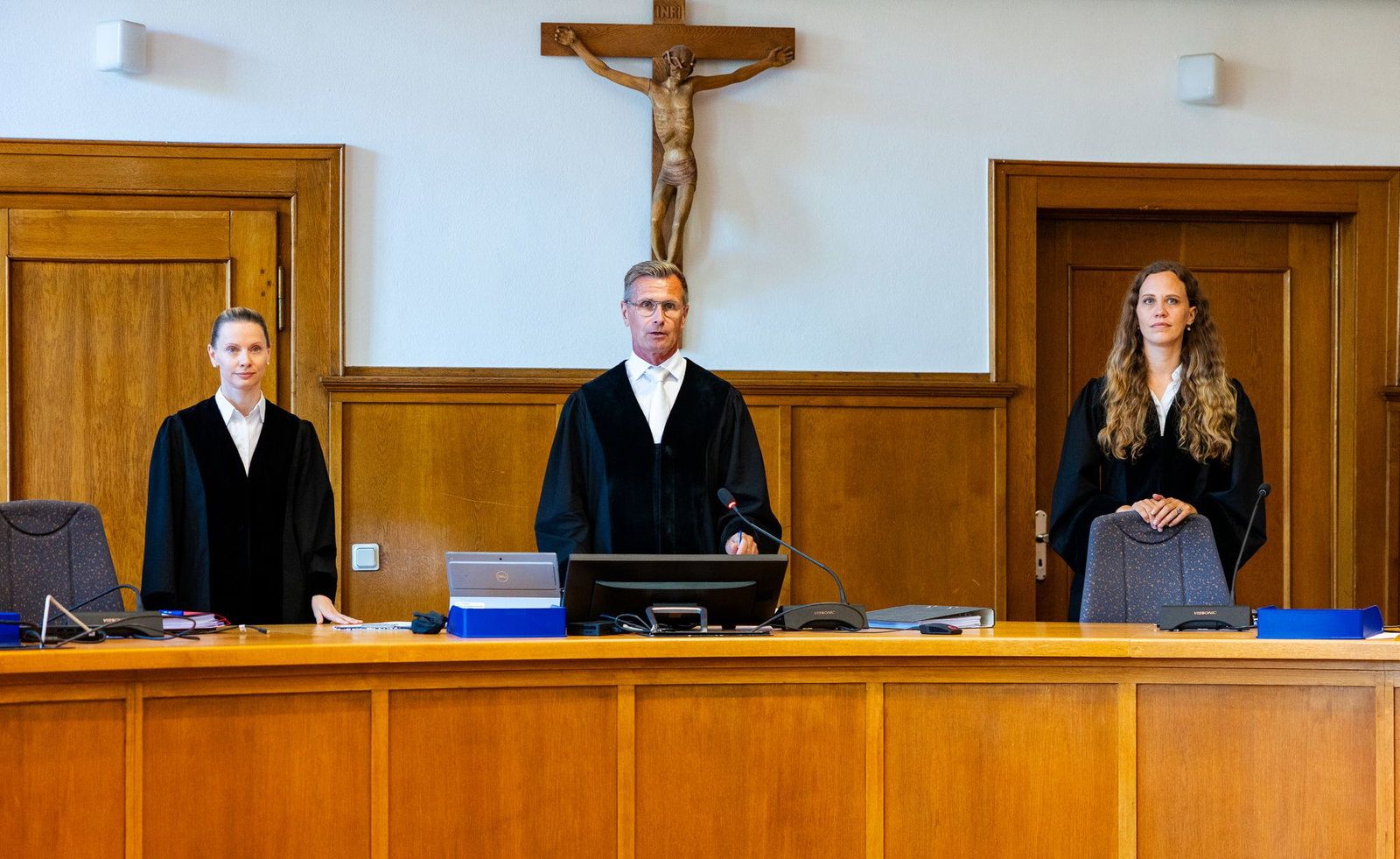 Der Vorsitzende Richter Klos (M) steht mit den Beisitzerinnen Hennersdorf und Christian auf der Richterbank im Saal 137 des Landgerichts.