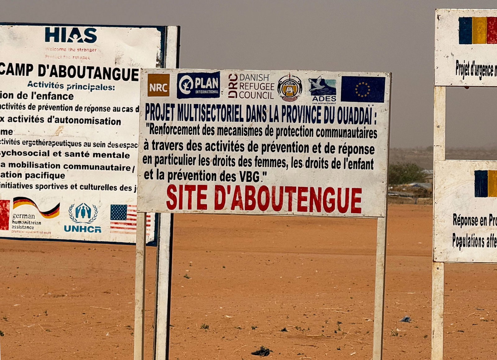 Auf dem Gelände eines Lagers für Flüchtlinge aus dem Sudan im Osten des Tschads stehen die Logos von Hilfsorganisationen, die dort im Einsatz sind. (Archivbild)