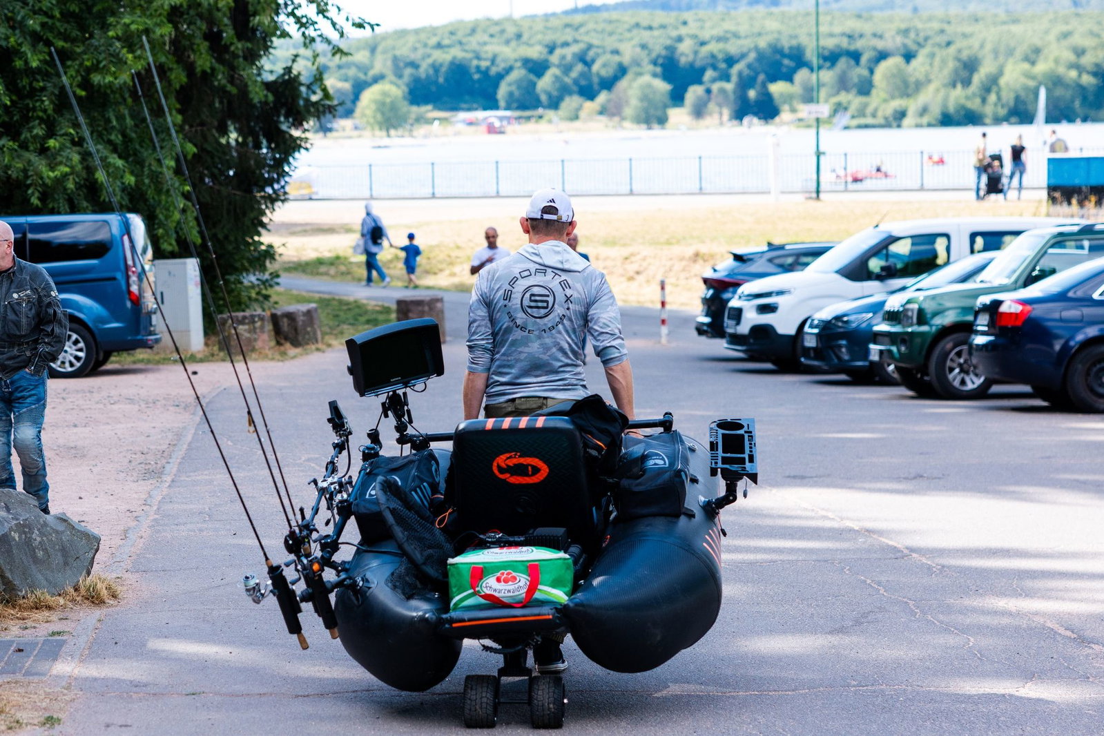 Ein Mann bringt sein Angelboot vom Parkplatz hinunter zum Bostalsee.
