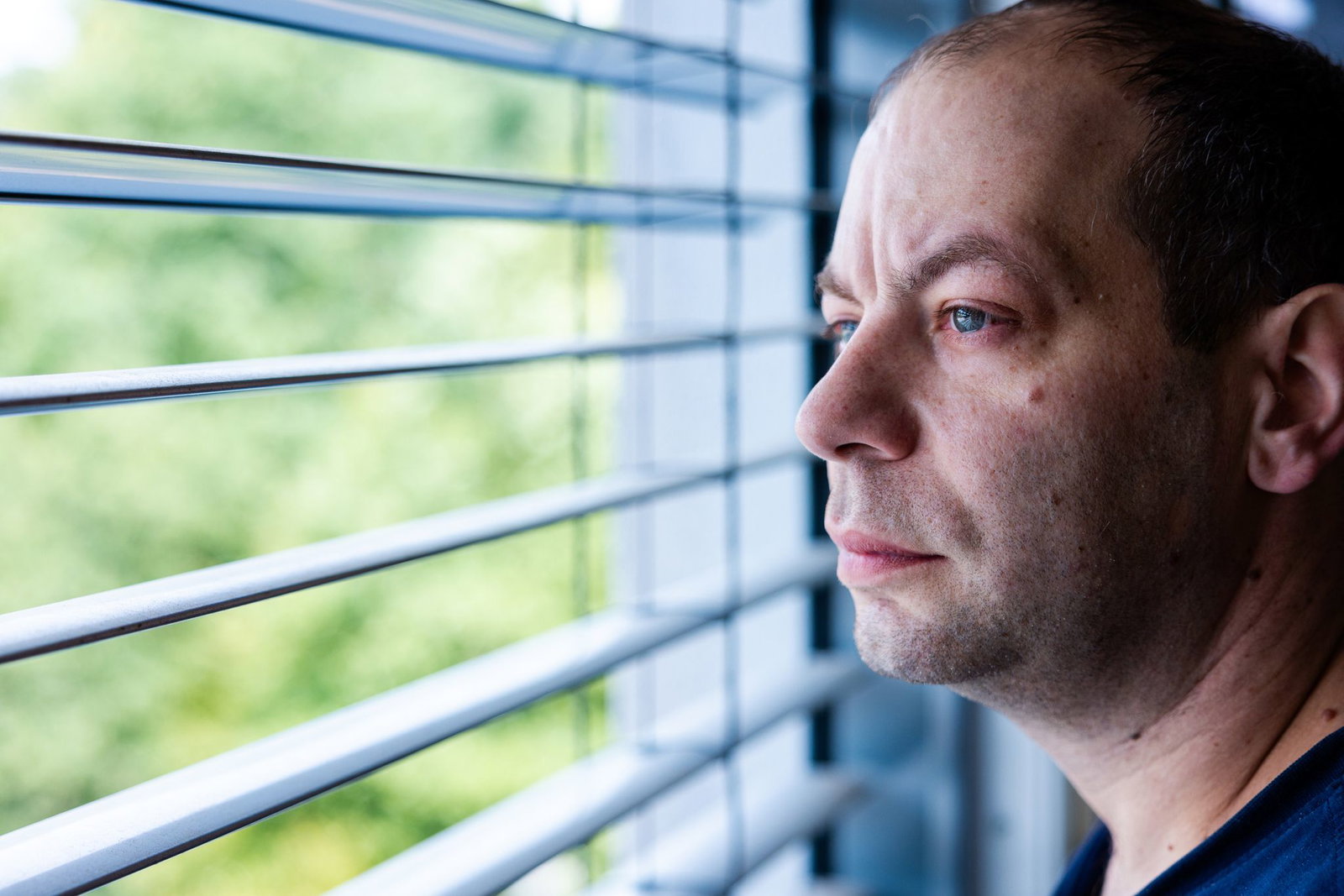 Patrik Oberleuck steht in seinem Krankenhauszimmer und schaut aus dem Fenster. Oberleuck leidet an Speiseröhrenkrebs.