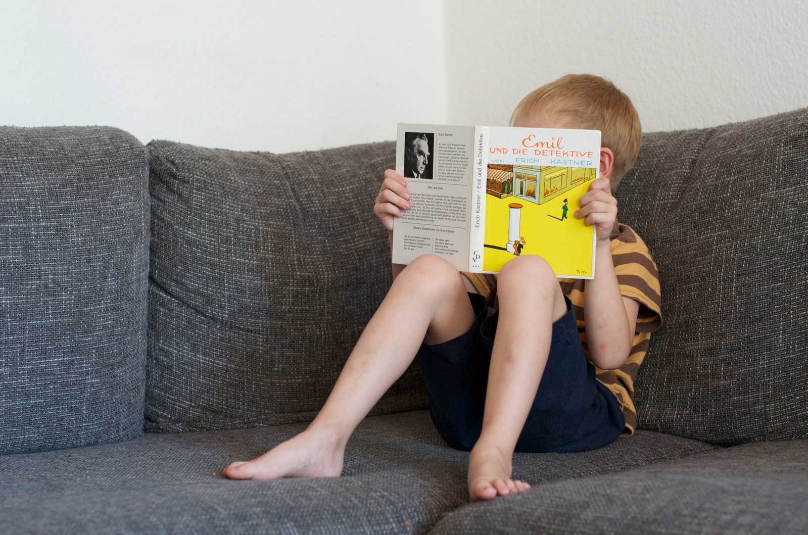 Ein Junge liest das Buch «Emil und die Detektive» von Kästner. (Archivbild)