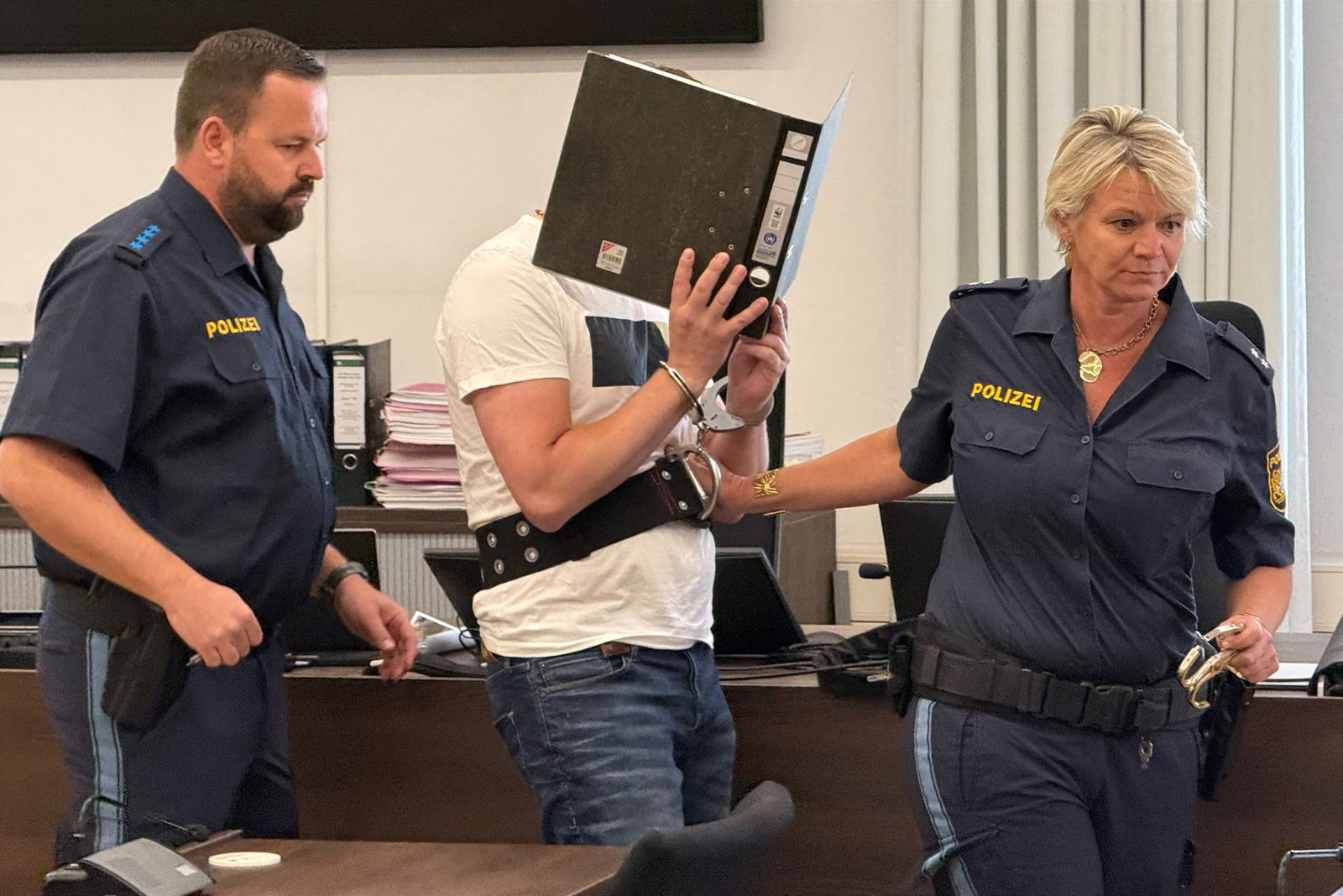 Vor dem Urteil wurde der Angeklagte von Polizisten zu seinem Platz geführt.