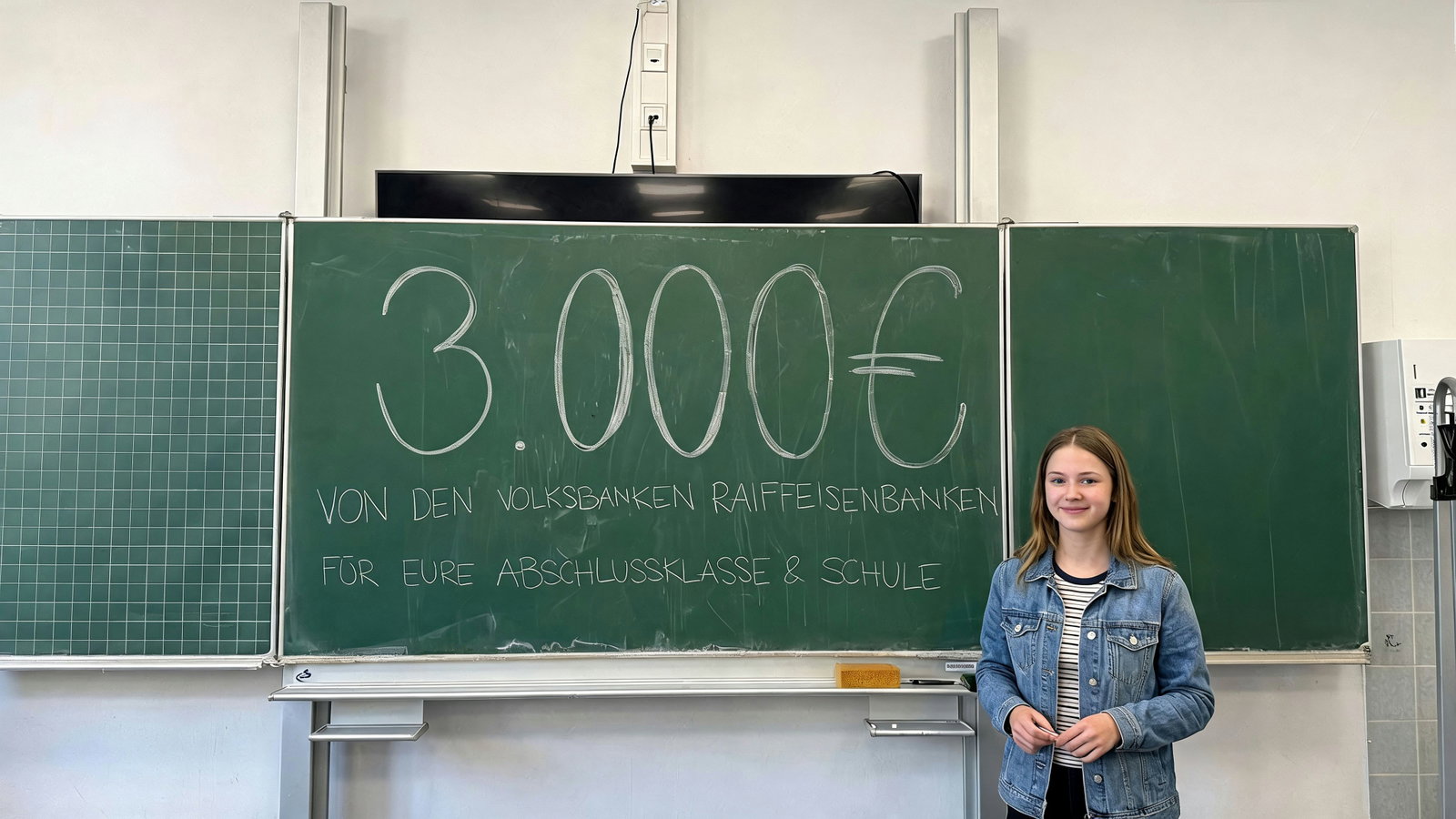 Headerbild: Ein Mädchen steht vor einer Tafel. 