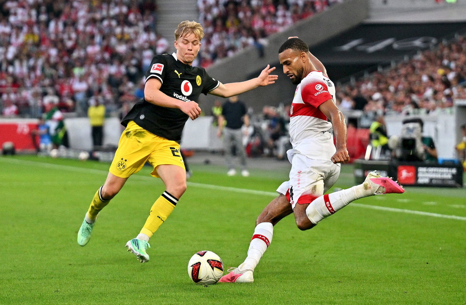 Bloß weg damit: Stuttgarts Josha Vagnoman (r) holt aus, beobachtet von BVB-Spieler Daniel Svensson.