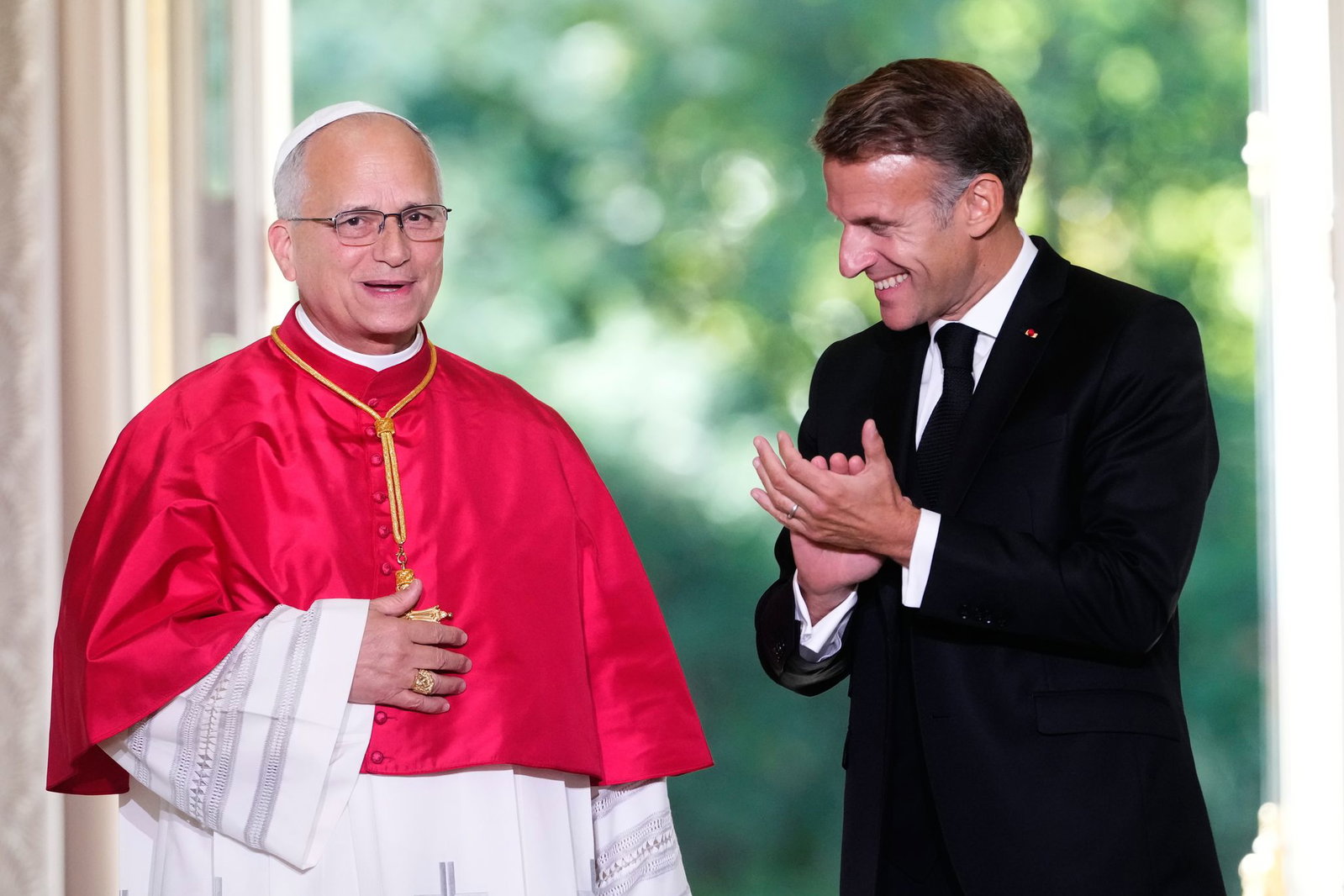 Frankreichs Präsident Emmanuel Macron beklatscht den Gast aus dem Vatikan.