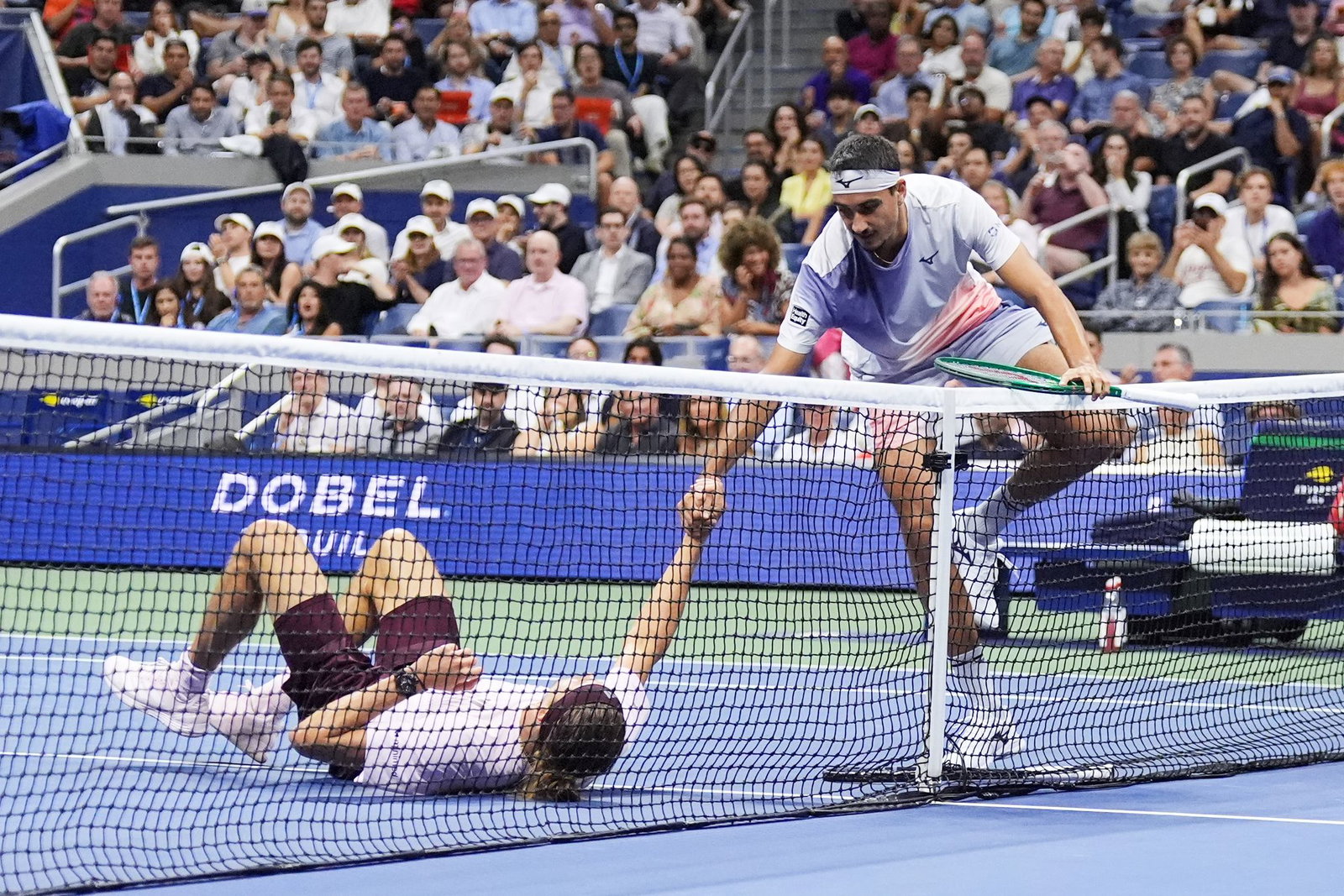 Lorenzo Sonego (r) hilft Zverev nach einem Strauchler wieder auf die Beine. 