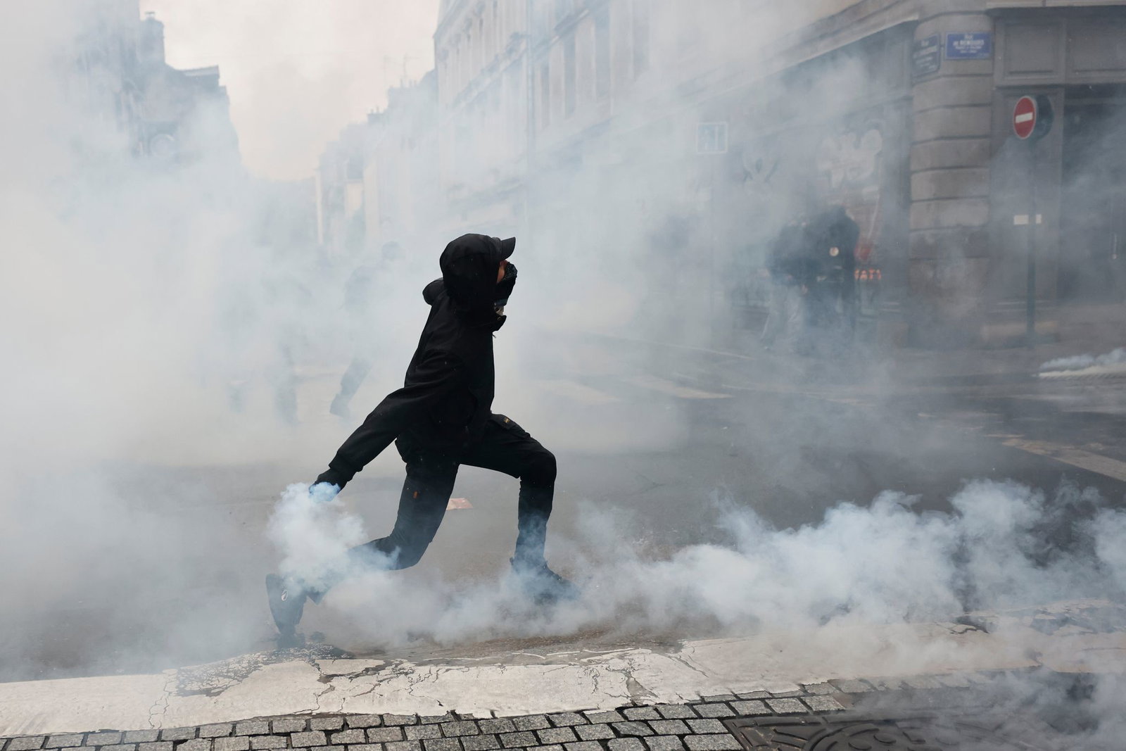 Ein Demonstrant wirft in Rennes eine Tränengasgranate in Richtung der Polizei.