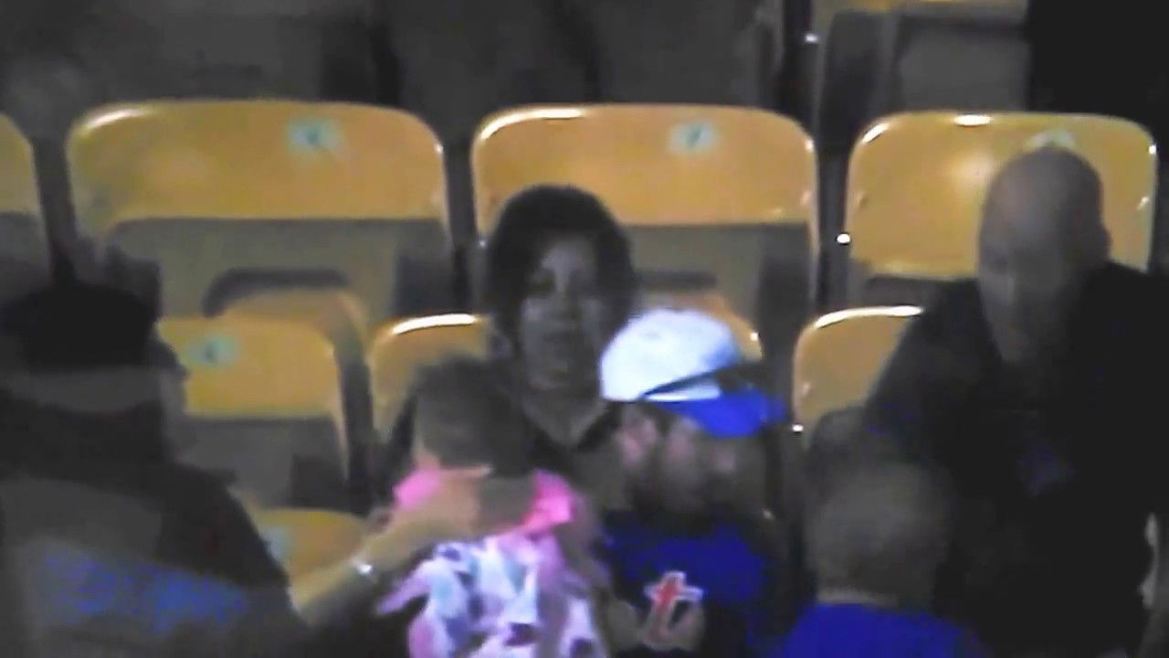 Mom angry as dad catches baseball with baby in arm